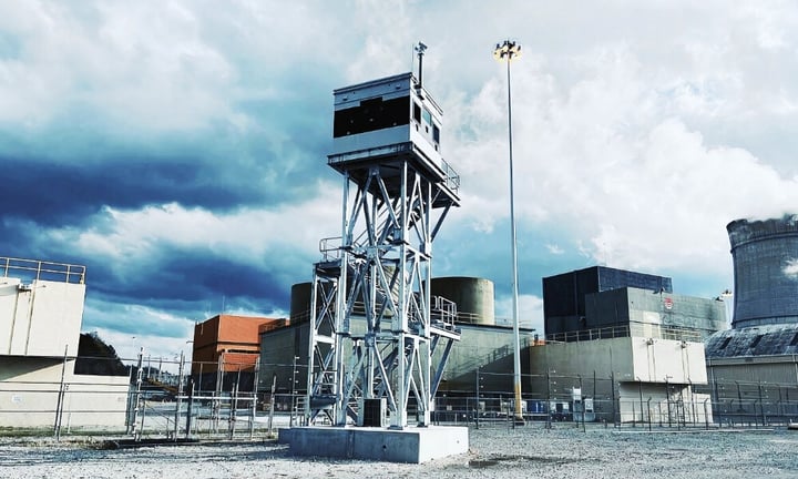 Guard tower deployed at a high-security nuclear facility, featuring an elevated observation booth, reinforced steel framework, and perimeter fencing for threat detection.